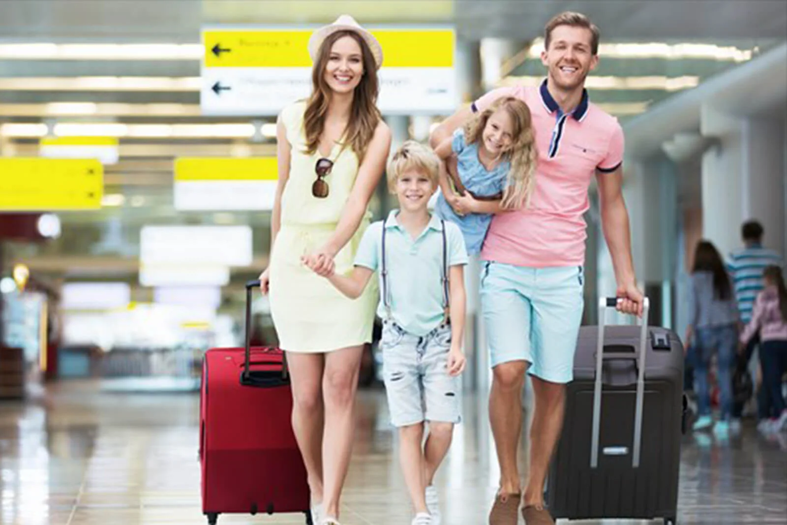 A family walking through an airport with luggage